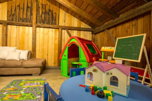 a play room with a table and a chalkboard at Forest Chalet, 15 min to salzburg olt town, and most beautiful lakes, secluded location, 1,000 sqm garden, mountainview, panorama sauna, bath whirlpool, BBQ&bikes&sunbeds for free, up to 10 p in Golling an der Salzach