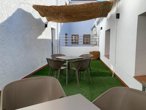 a patio with chairs and a table and grass at Hostal El Bomba 