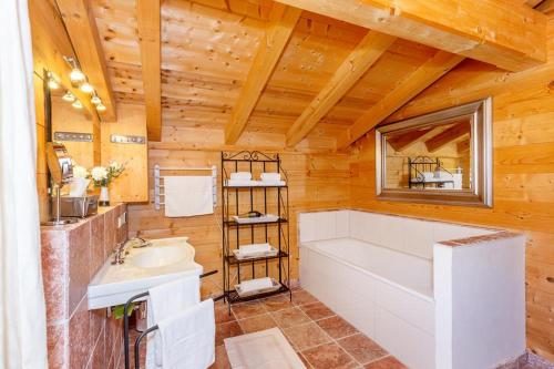 uma casa de banho com uma banheira branca e um lavatório. em Ferienhaus Hirschhäusl em Reit im Winkl