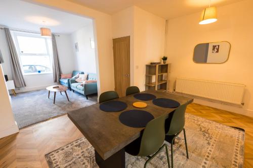 a living room with a dining room table and chairs at Amazing new 3 double bed house in staple hill! in Bristol