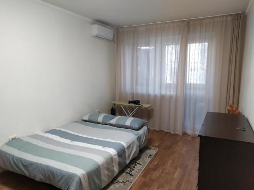 1 dormitorio con cama, escritorio y ventana en Квартира Добровольского, 105 en Odesa