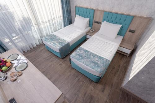 A bed or beds in a room at Anadolu Hotels Didim Club - Ultra All Inclusive ex Palmwings