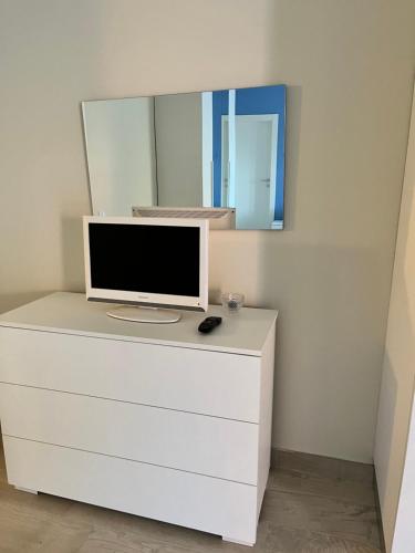 a computer monitor on a dresser with a mirror at Casa Cost 2 in Vetralla