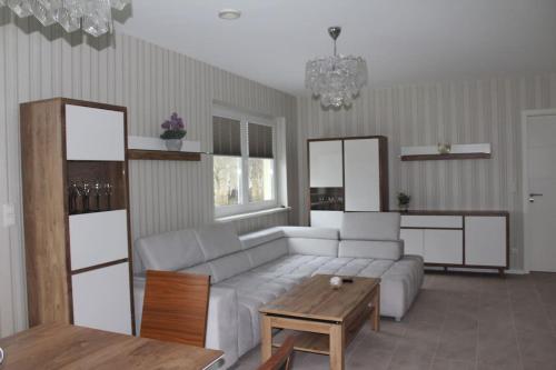 a living room with a white couch and a table at Ostsee-Luxus-Ferienwohnung Sanitz in Sanitz