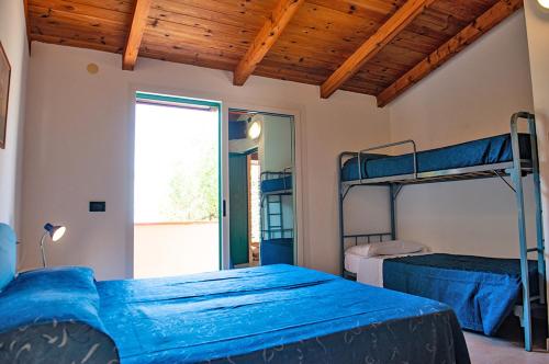 1 dormitorio con 2 literas y ventana en Lido Paradiso Resort, en Pisciotta