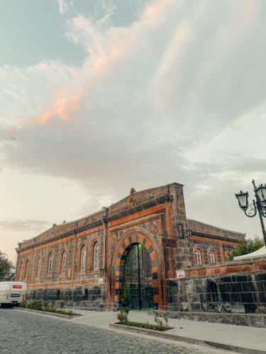 a large brick building with an archway on a street at Modern apartment in the heart of Gyumri in Gyumri