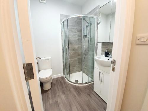 uma casa de banho com um chuveiro, um WC e um lavatório. em Beautiful Modern Studio Town Centre Close to Beach em Bournemouth