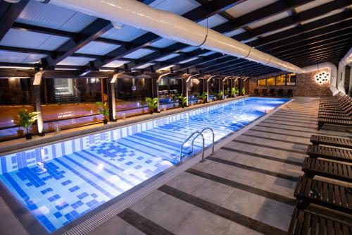 a large swimming pool with blue lighting in a building at Hotel Putnik Kopaonik in Kopaonik