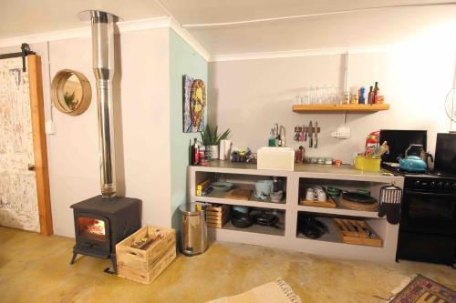 a kitchen with a stove and a shelf with food at Starry Starry Night - Route 62 in Montagu