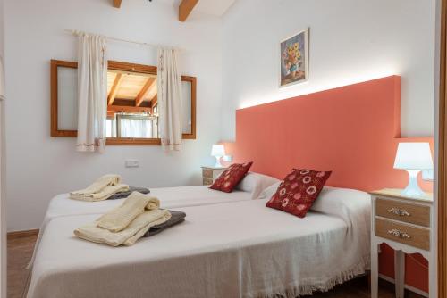 twee bedden in een kamer met rode en witte muren bij Sunset Finca Can Gosp in Alcudia