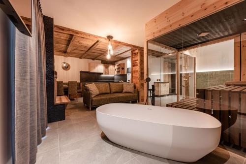 a bathroom with a large tub and a living room at Nidaris - Luxury Private Spa Suites in Malè