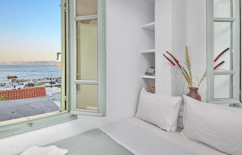 een kamer met een raam met uitzicht op de oceaan bij Faros Coastal Apartments in Skopelos Town