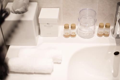 a bathroom counter with a sink and some bottles on it at City-Hotel Am Wasserturm Halle in Halle an der Saale