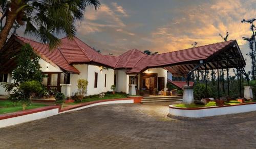 a house with a red roof and a driveway at Unlock By Goldfinch Sakaleshpur in Kenchamman Hoskota