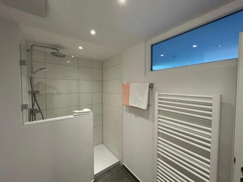 a bathroom with a shower and a large window at Haus Belvedere in Berchtesgaden
