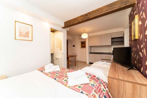 a bedroom with two twin beds and a kitchen at Castello Central & Panoramic Studio in Turin