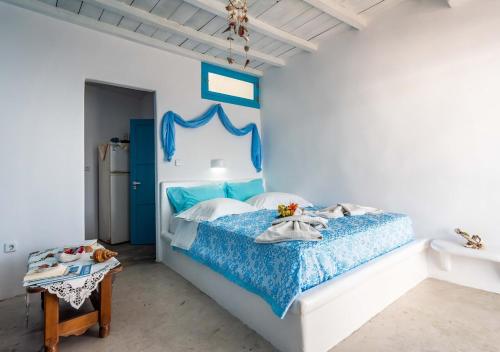 a blue and white bedroom with a bed and a table at Last Sirma Klima in Klima