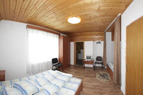 Un dormitorio con una cama y un techo de madera. en Pensiunea Pui de Urs Sirnea, en Fundata