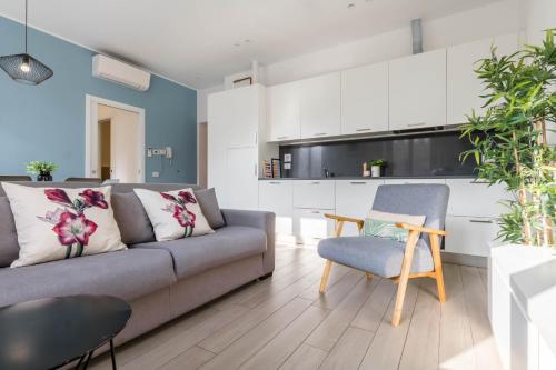 a living room with a couch and a kitchen at JOIVY Mazzini Brera in Milan