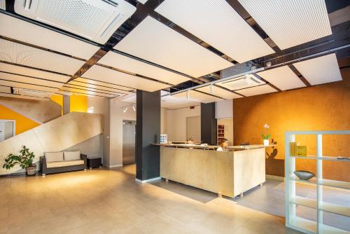 an office lobby with a reception counter and a staircase at Hotel La Pergola Dependance in Lignano Sabbiadoro