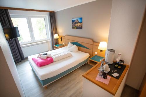 a small bedroom with a bed and a table at Das Loft Hotel Willingen in Willingen