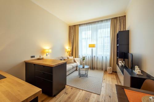 a living room with a couch and a table in a room at Design Merrion Hotel in Prague