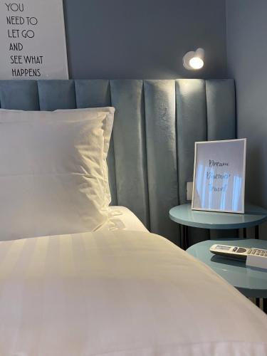 a bed with a pillow and a picture on a table at Living Studio Apartments in Tirana