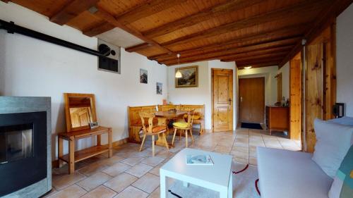 a living room with a fireplace and a table at Les Hirondelles, cosy apartment with a magnificent view on the mountains in La Forclaz