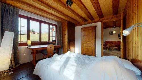 a bedroom with a large white bed in a room at Les Hirondelles, cosy apartment with a magnificent view on the mountains in La Forclaz