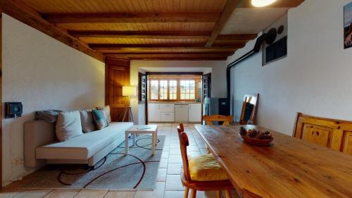 a living room with a couch and a table at Les Hirondelles, cosy apartment with a magnificent view on the mountains in La Forclaz