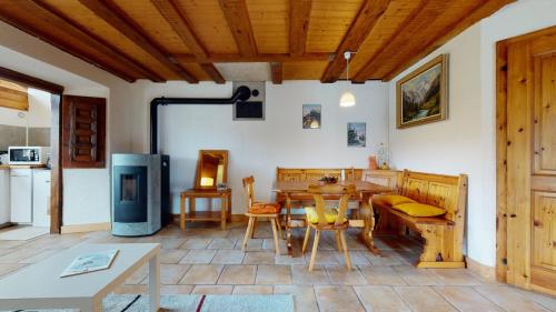a living room with a table and a kitchen at Les Hirondelles, cosy apartment with a magnificent view on the mountains in La Forclaz