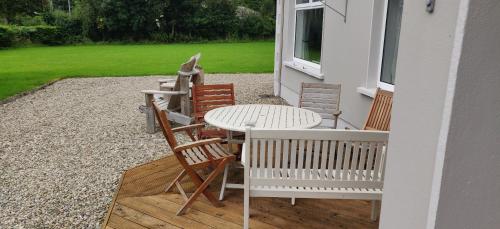 a patio with a table and chairs on a porch at Rossgier bungalow in Lifford