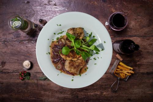 a plate of food with meat and beans on a table at Resort Mezná in Hřensko
