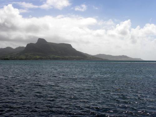 a large body of water with mountains in the background at Le Jardin de Beau Vallon in Mahébourg
