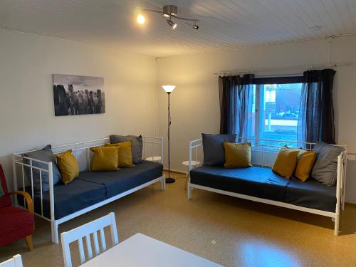 a living room with a blue couch and yellow pillows at Economy Apartments Peura in Rovaniemi