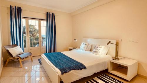 アルブフェイラにあるBicos U by Check-in Portugalのベッドルーム1室(ベッド1台、椅子、窓付)