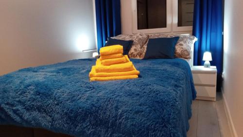 Una cama con toallas amarillas encima. en Apartament Jakubek, en Polkowice