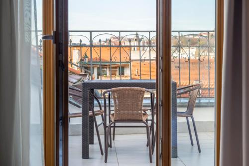 a table and chairs on a balcony with a view at Janackovo - Riverside Residence in Prague