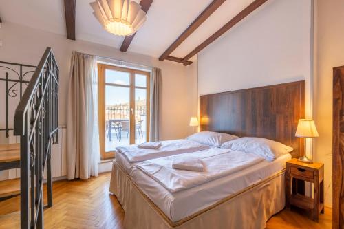 a bedroom with a large bed and a large window at Janackovo - Riverside Residence in Prague