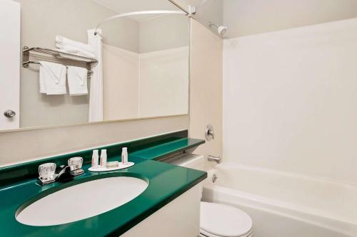 a bathroom with a sink and a toilet and a mirror at Super 8 by Wyndham Helena in Helena