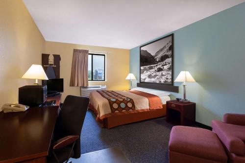 a hotel room with a bed and a chair at Super 8 by Wyndham Helena in Helena