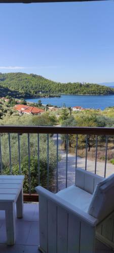 a balcony with a bench and a view of the water at Skalopati Studios & Villa in Panormos Skopelos