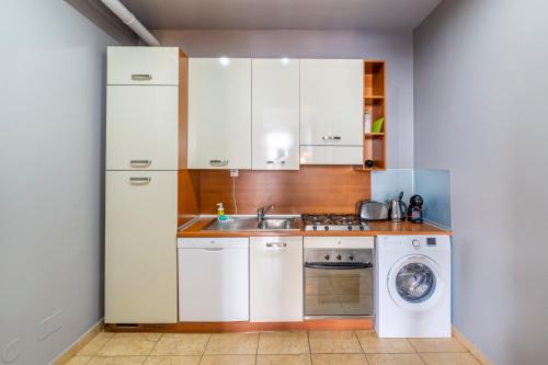 a kitchen with a sink and a washing machine at Janackovo - Riverside Residence in Prague