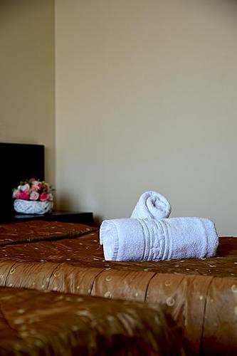 a pair of towels sitting on top of a bed at Pensiunea Eric in Iaşi