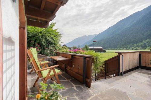 a balcony with a table and chairs and mountains at Appartements-Klaus in Neustift im Stubaital