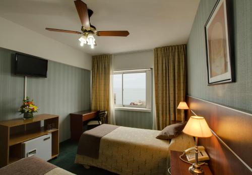 Hotel 13 de Julio في مار ديل بلاتا: غرفه فندقيه بسرير ونافذه