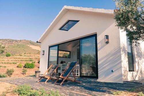 a house with two chairs and a table on a patio at Casa do Losango - the Douro river as a border in Coleja
