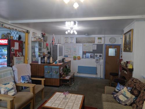 a living room filled with furniture and a refrigerator at HARLOW INTERNATIONAL HOSTEL in Harlow