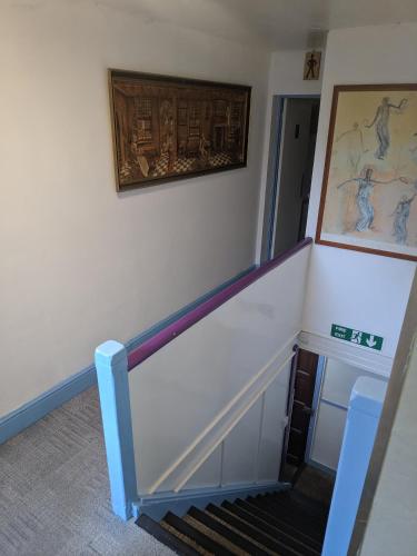 a room with a staircase with a painting on the wall at HARLOW INTERNATIONAL HOSTEL in Harlow