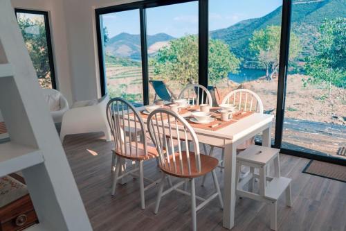 a dining room with a table and chairs and a large window at Casa do Losango - the Douro river as a border in Coleja